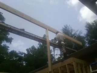 Carpenter setting a ridge beam over a new addition frame — Ice Dam Removal by Roofing Brothers in Windsor Heights