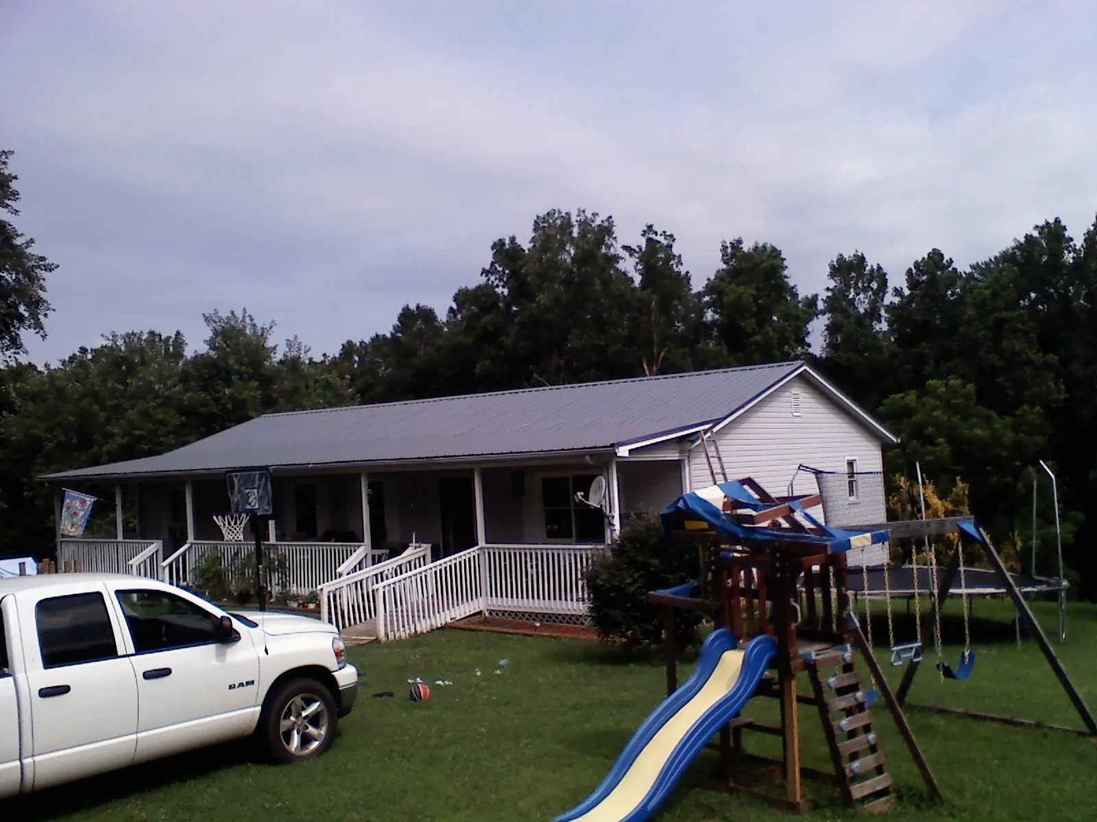 Dark metal roof on a country home with a full length front porch in Windsor Heights