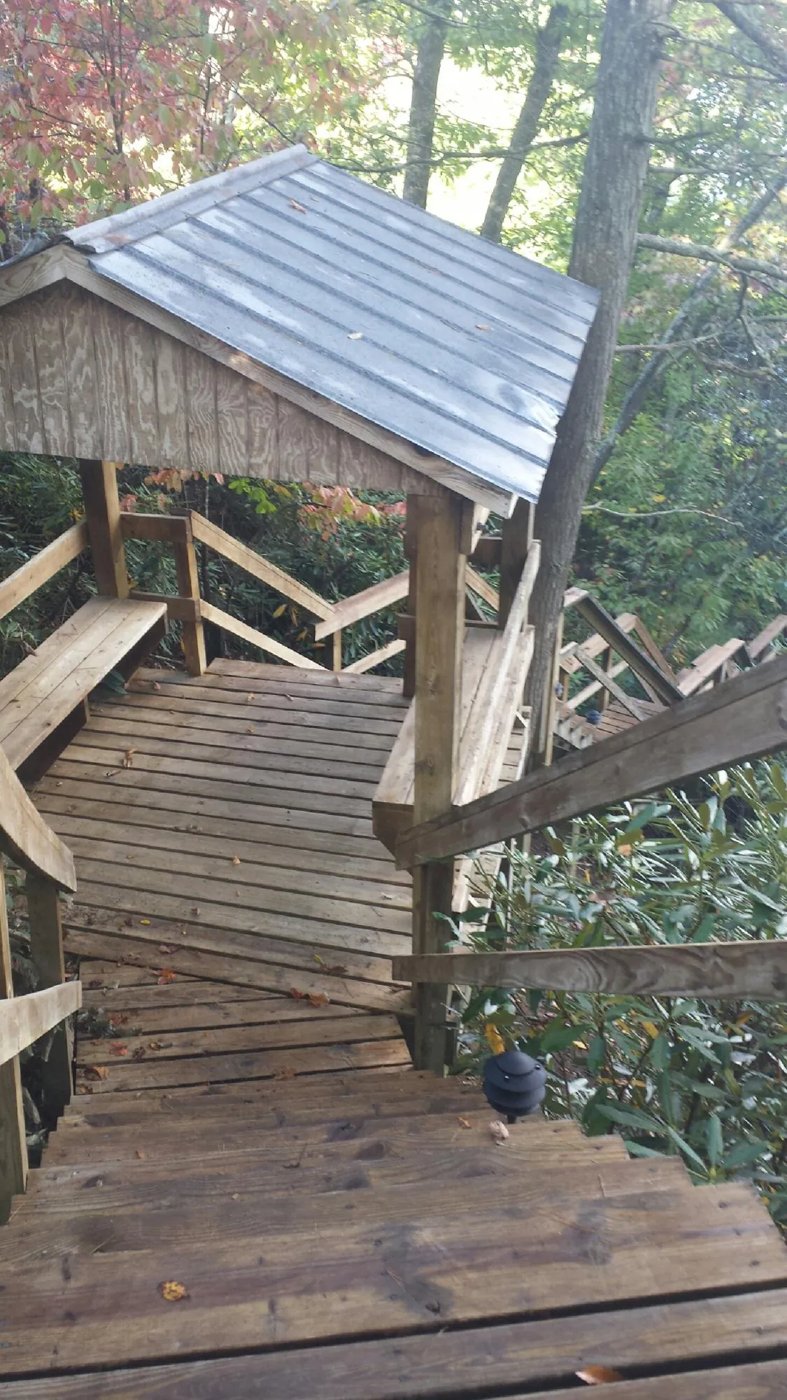 Metal roofed shelter over wooden steps on a wooded walkway — Skylight Repair & Installation work by our crew in Windsor Heights